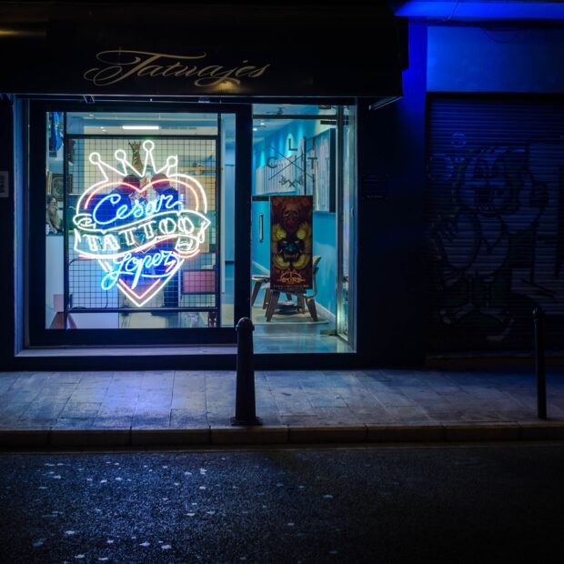 entrada de um estudio de tatuagem cores fortes dentro do estúdio por fora rua escura
