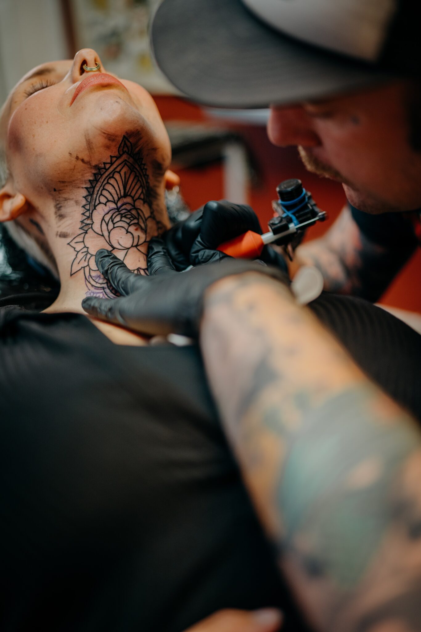 Homem-tatuando-o-pescoco-luvas-pretas-braco-todo-tatuado