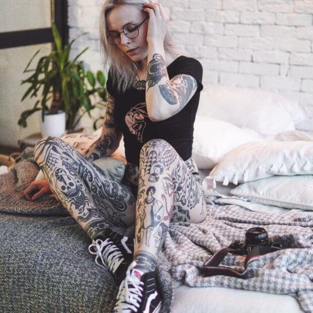 Mulher-assentada-na-cama-toda-tatuada