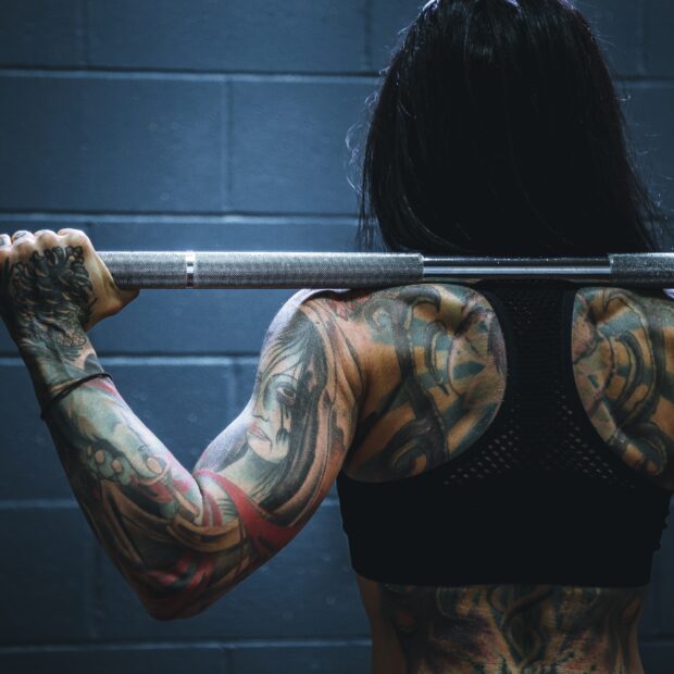 mulher-costas-toda-tatuda-levantando-peso
