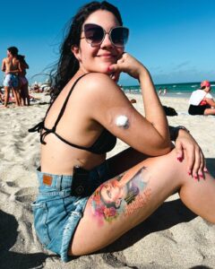 Biabetia tomando sol na praia toda tatuada